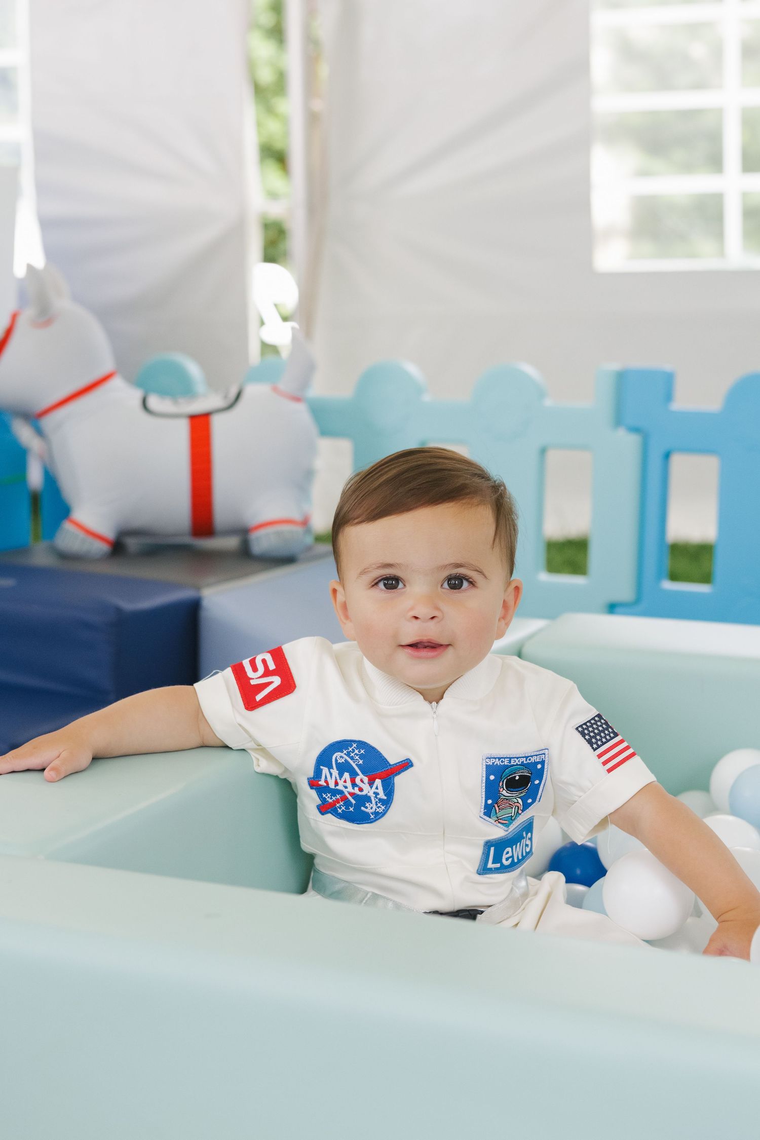 Excited birthday boy explores the soft play area, celebrating his first birthday with colorful, interactive fun.