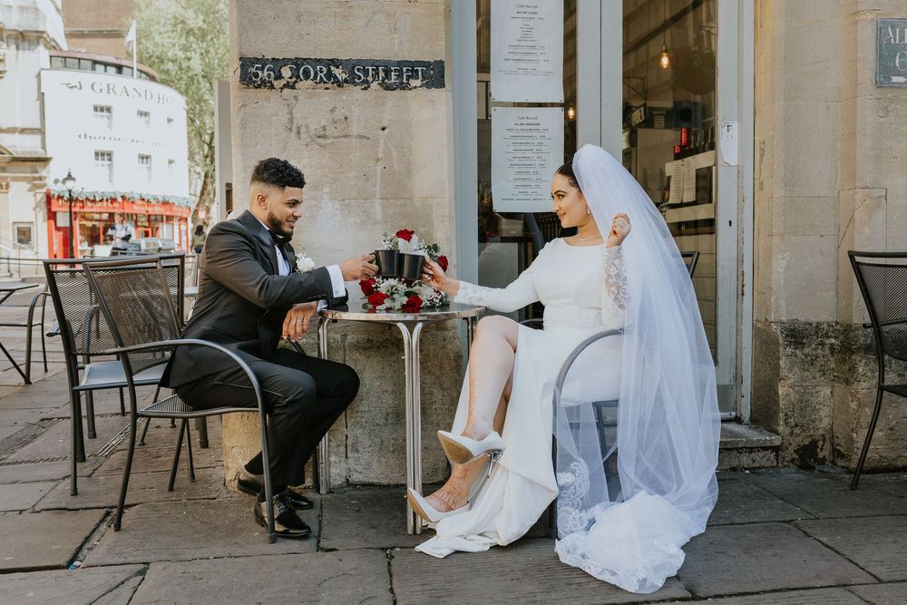 Bride and groom share intimate moments together at an outdoor cafe venue during their wedding photo session.