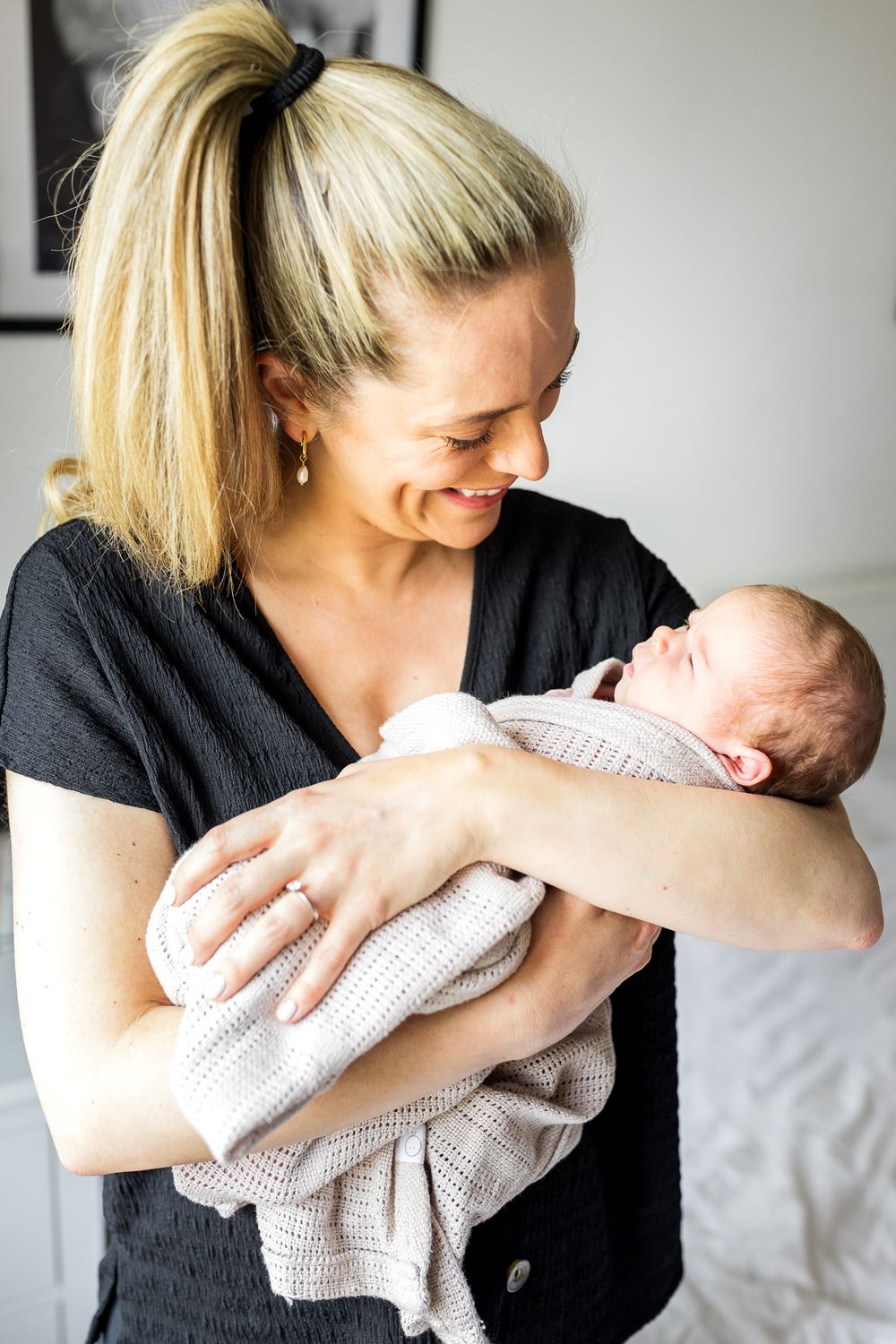 mum holding a newborn baby girl wrapped in a blanket