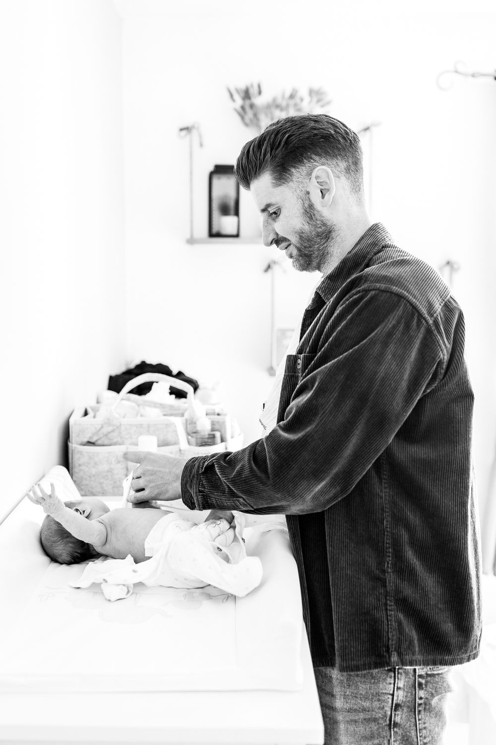 candid moment of dad changing baby's nappy