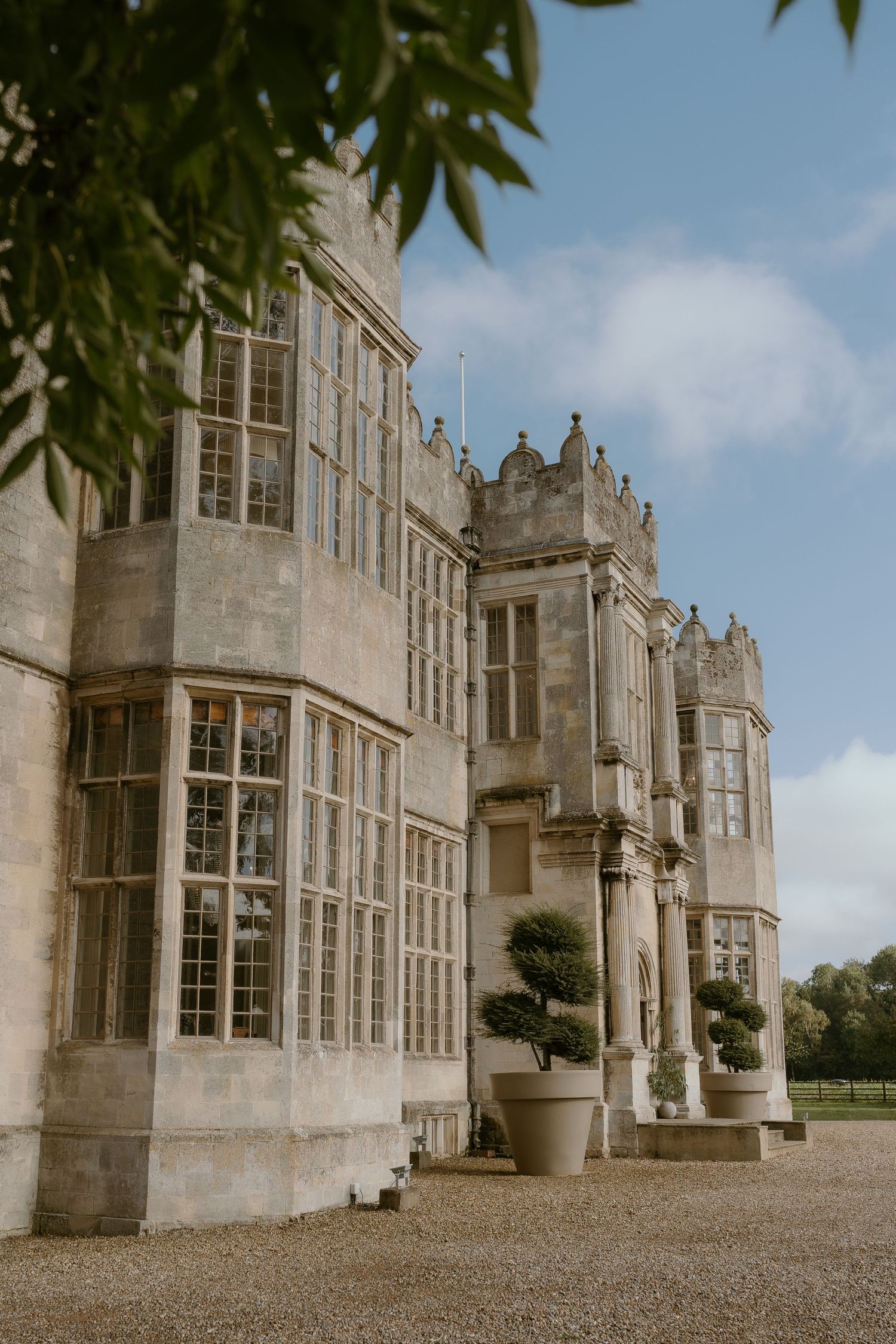 Gothic revival architecture of a grand stone mansion with bay windows and ornate details at Howsham Hall.