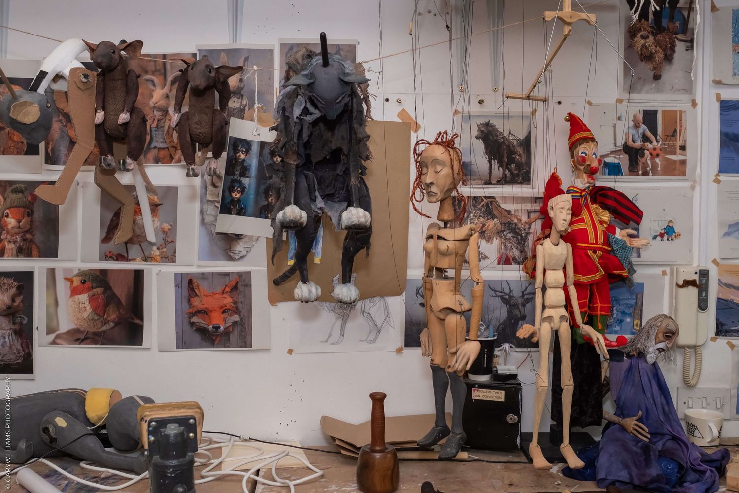 Display wall featuring various costume pieces and theater props hung for storage.