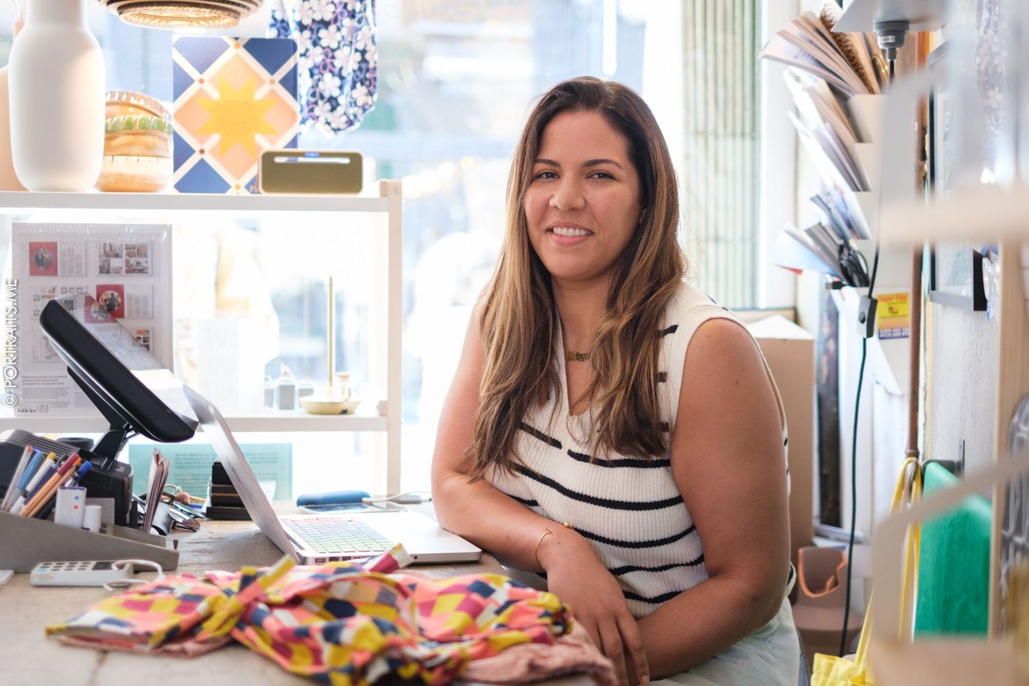 Woman behind counter in bright retail space with point of sale system.
