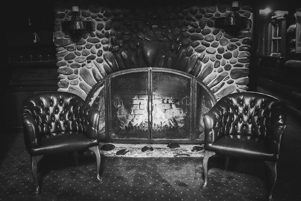 Black and white photo series shows progressive lighting up of neon arched design creating an illuminated walkway effect.