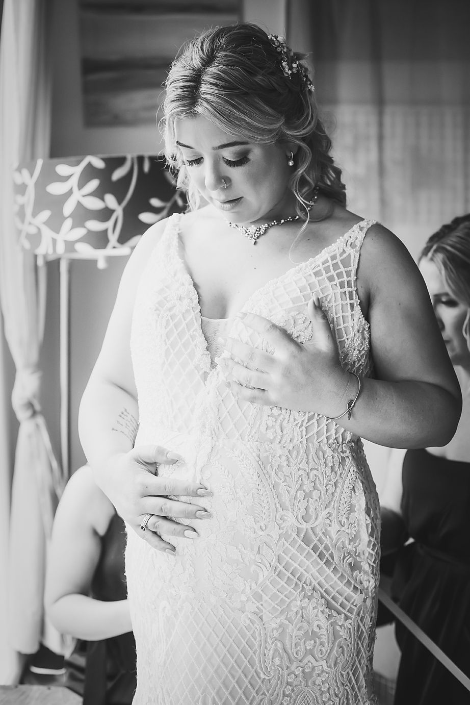 A bride wearing an elegant lace wedding dress in black and white preparing for her big day.