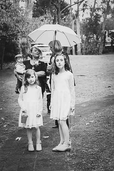 Four vintage black and white photographs show children with parasols playing outdoors in white dresses.