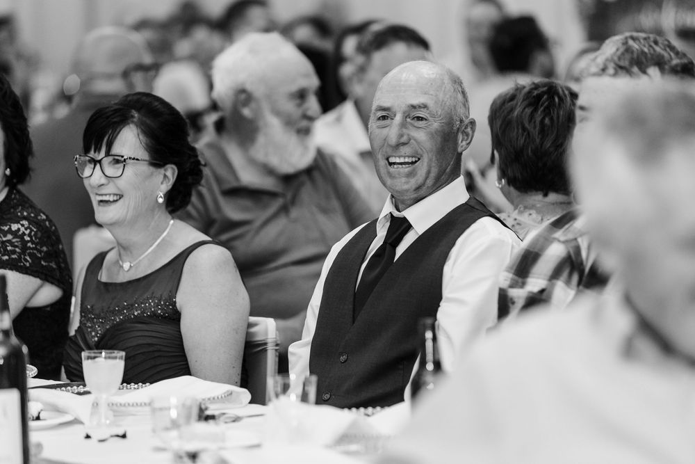 People enjoying themselves at a formal dinner reception, shown in black and white photography.