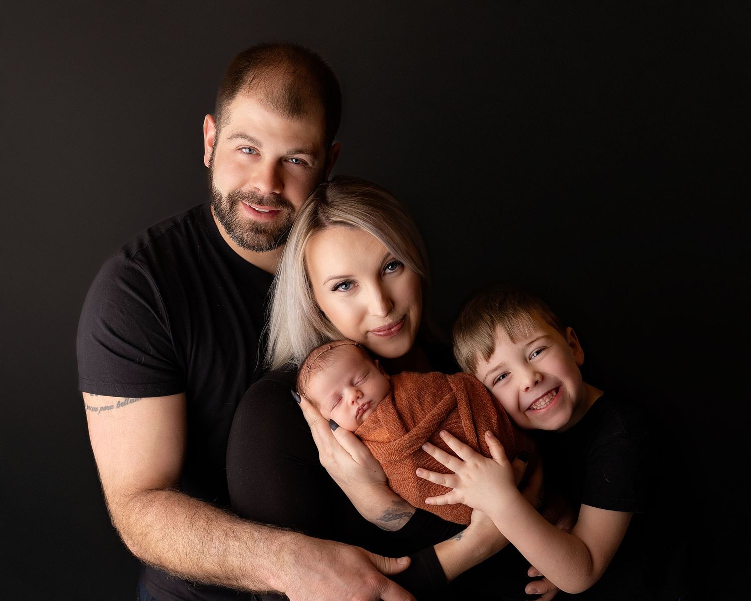 Professional photo of a newborn baby with brother, mother, and father