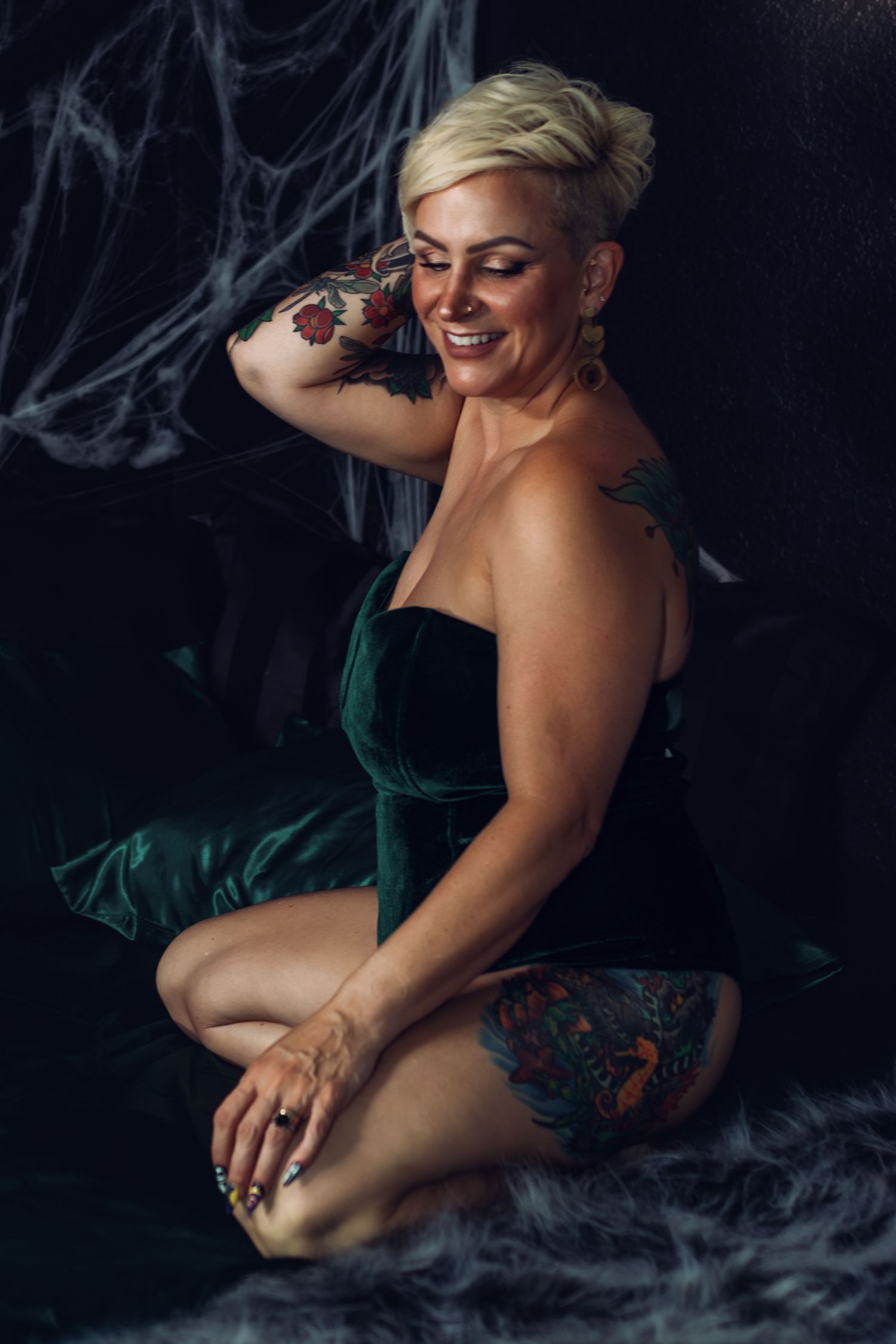 A woman smiles during her fun and empowering boudoir session in Fort Worth boudoir studio.