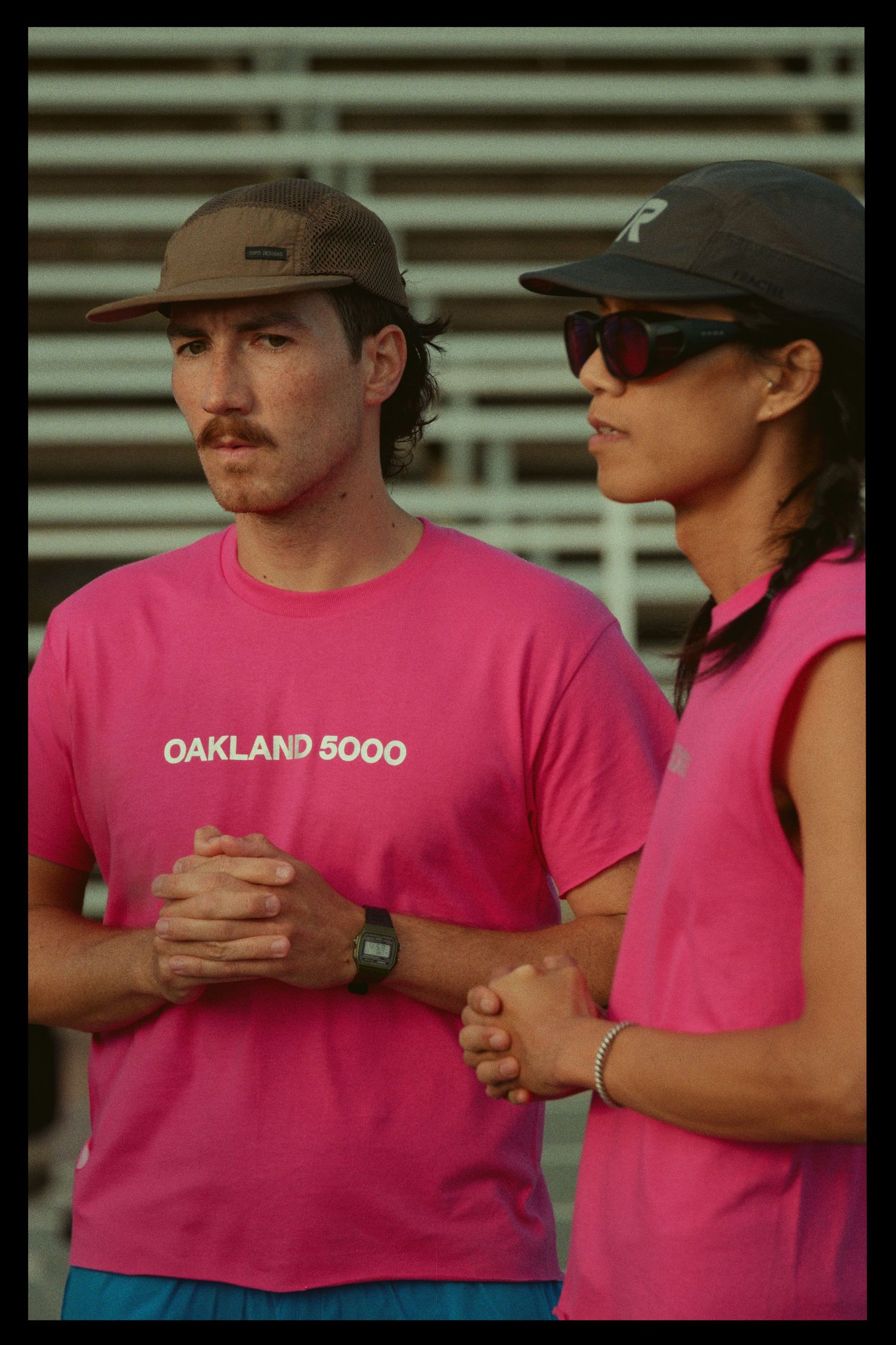 People wearing pink t-shirts stand close together in a casual setting.