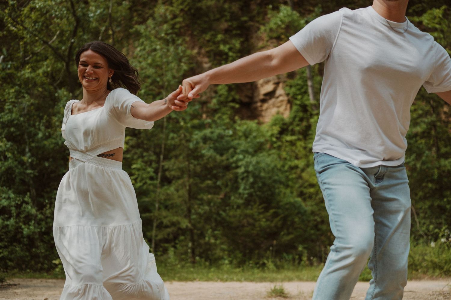 A candid moment captured between two people dancing outdoors in casual attire.