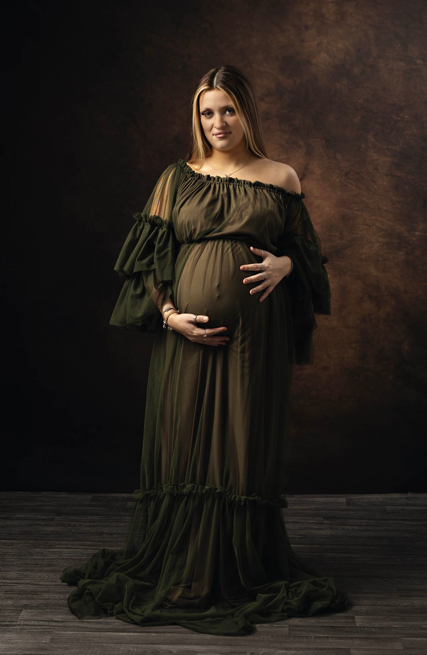 Maternity portrait in olive green gown in classic studio style. Tiny moments newborn and maternity photography in Hampshire photo studio