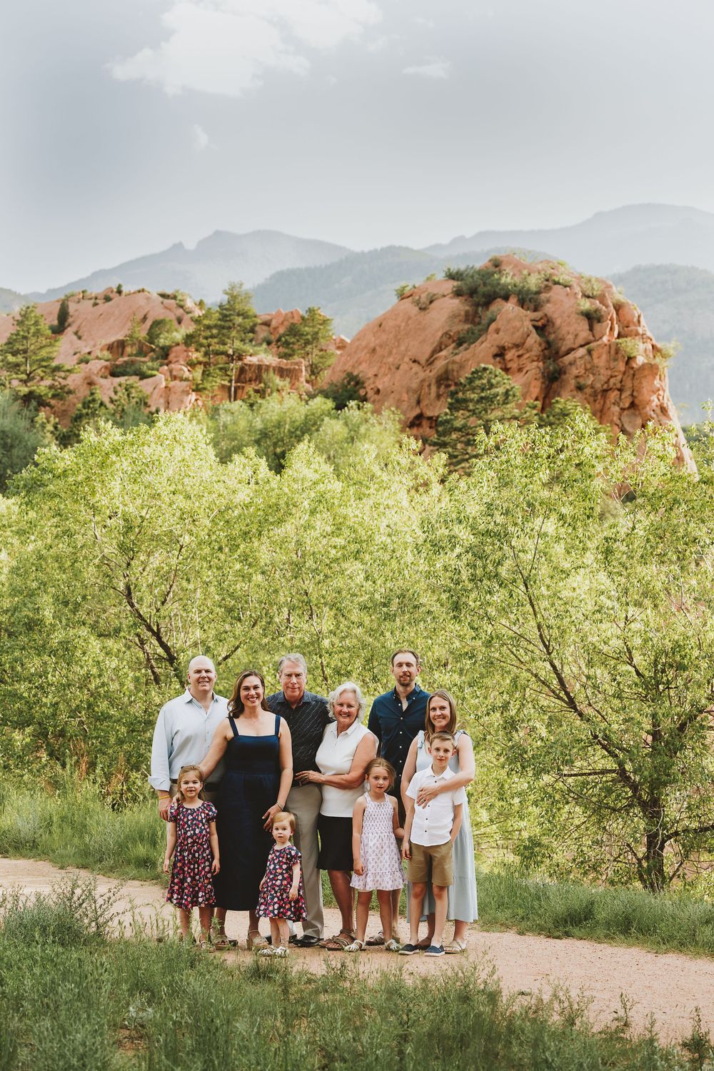 Group standing on dirt path with red rock formations and mountains of Garden of the Gods park in Colorado Springs.