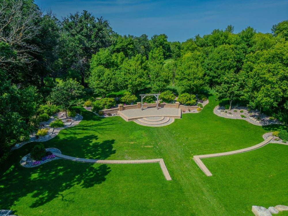 Aerial view of a beautifully landscaped garden area with winding paths and stone features.