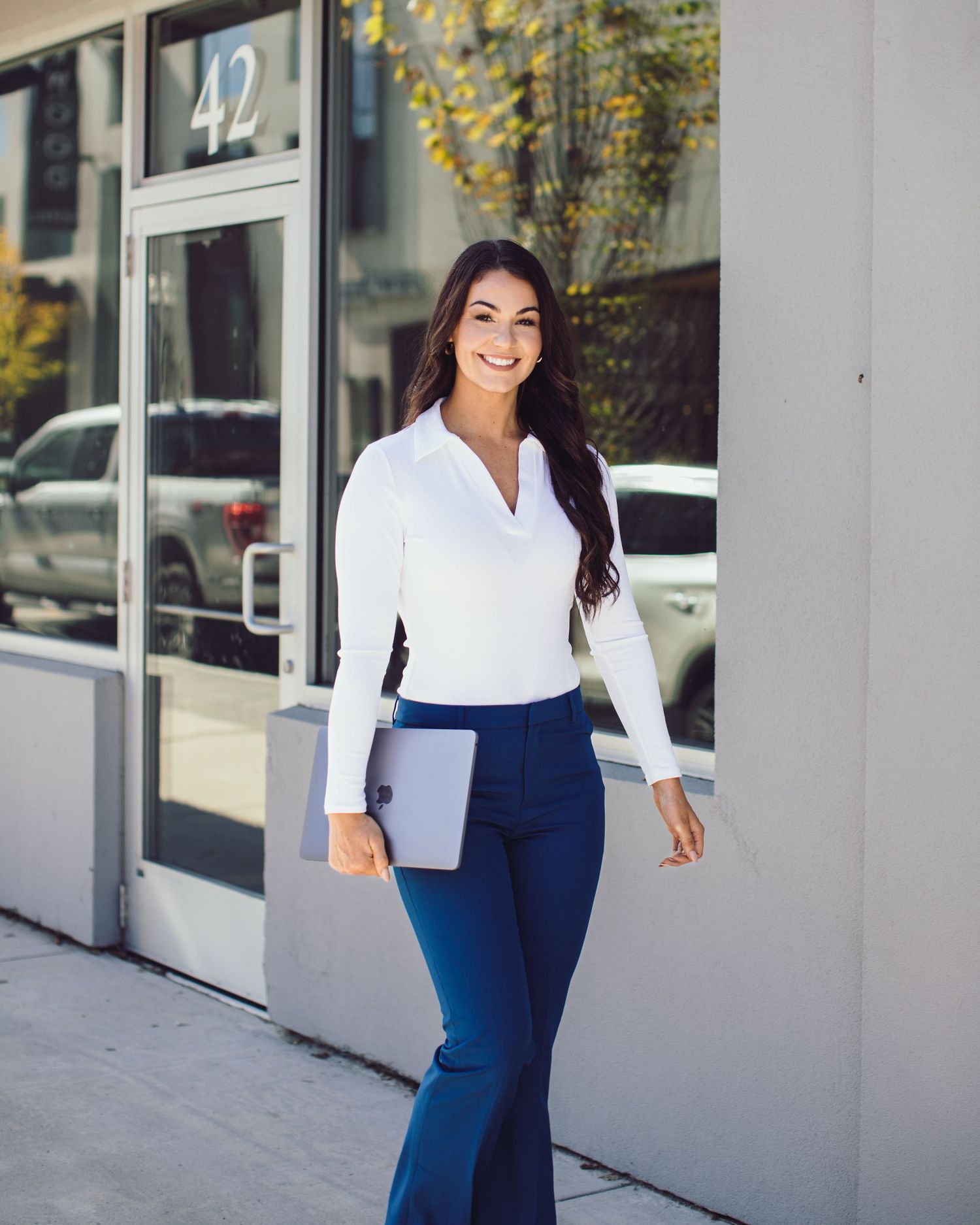 Professional photo of a women with her laptop walking down the street