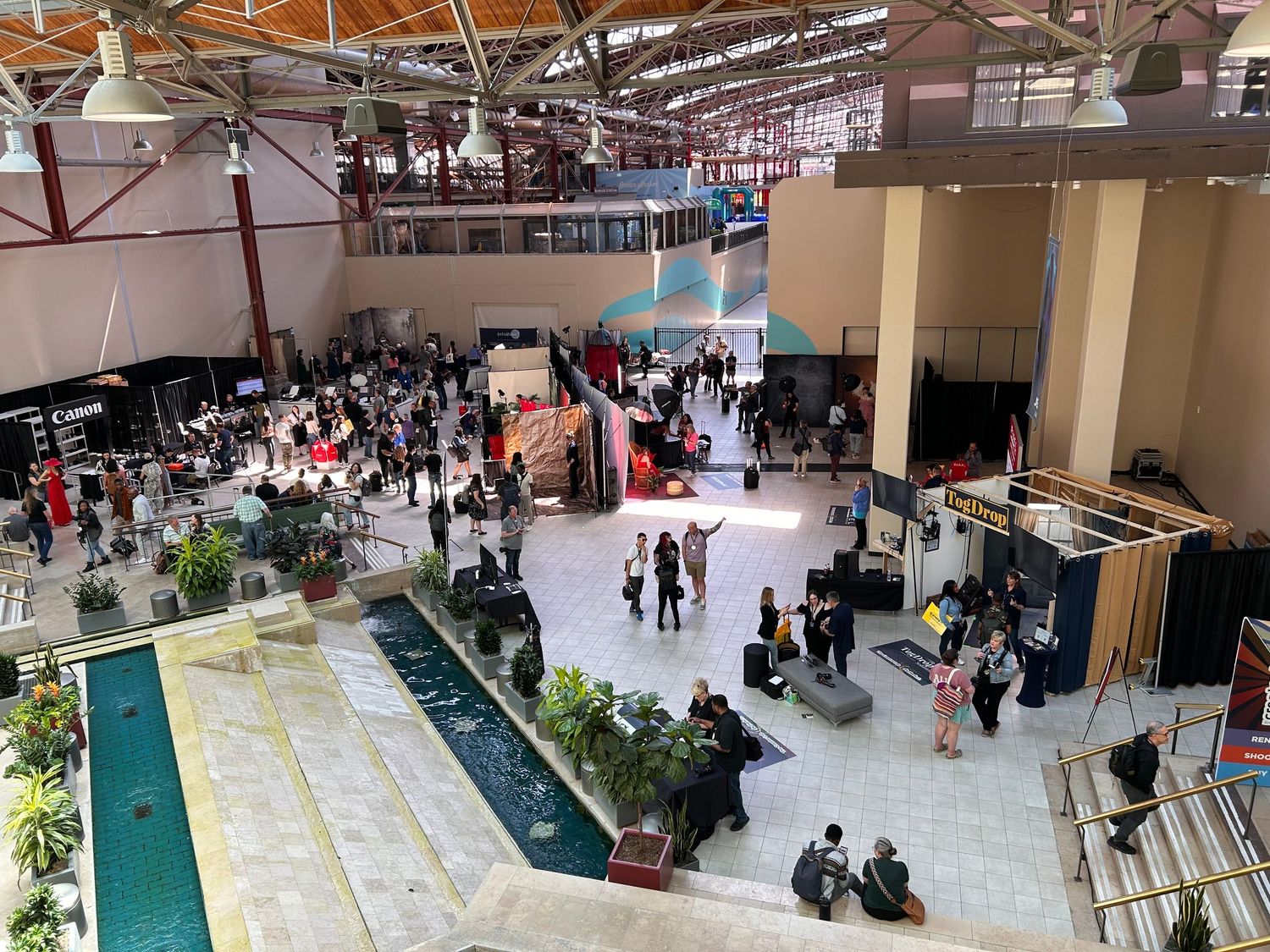 Tiered indoor market or shopping center with multiple levels and large skylights visible from above.