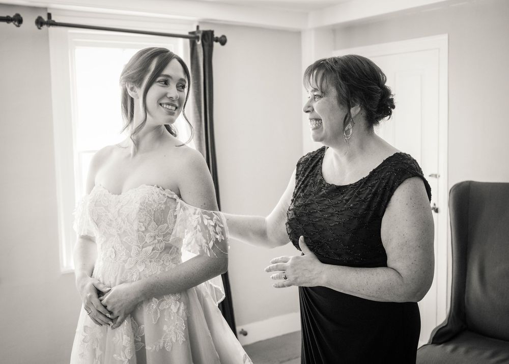A black and white photo sequence showing a bride getting help with putting on her wedding dress before the ceremony.