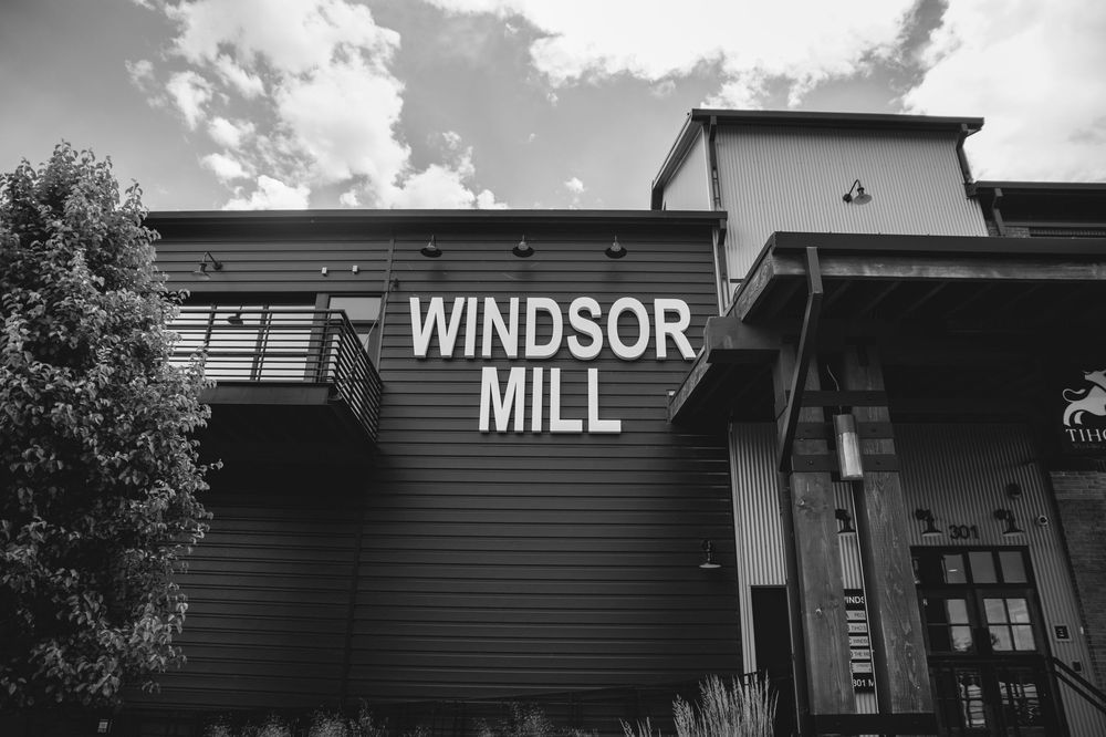Historic Windsor Mill sits against a cloudy sky with facades showing characteristic industrial architecture details.