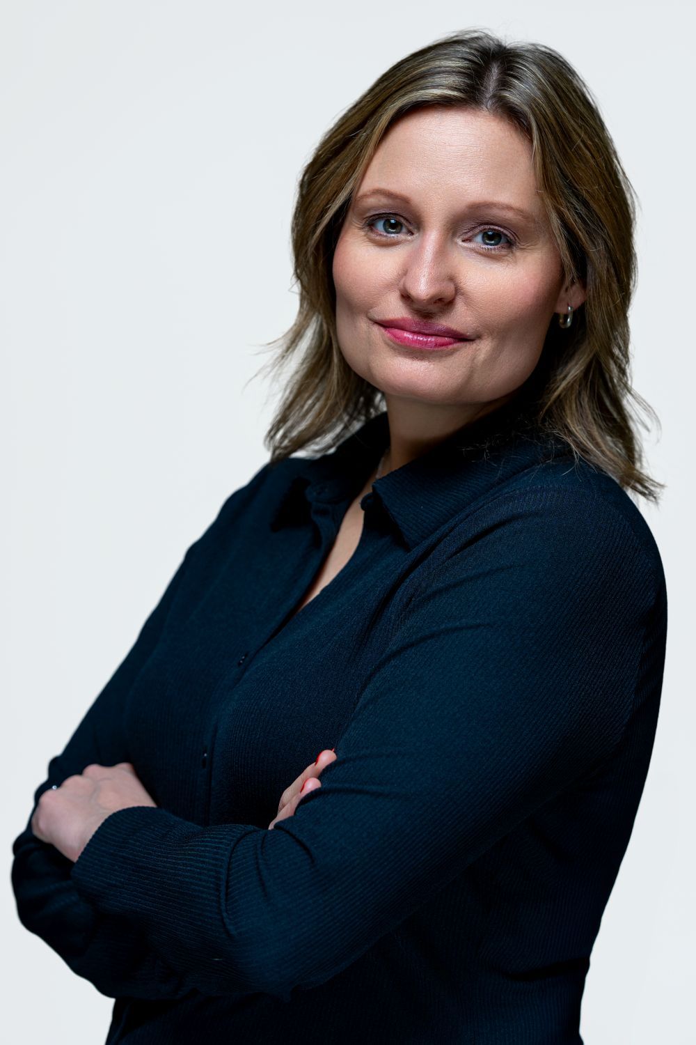 Professional portrait of someone in a black shirt against white background.