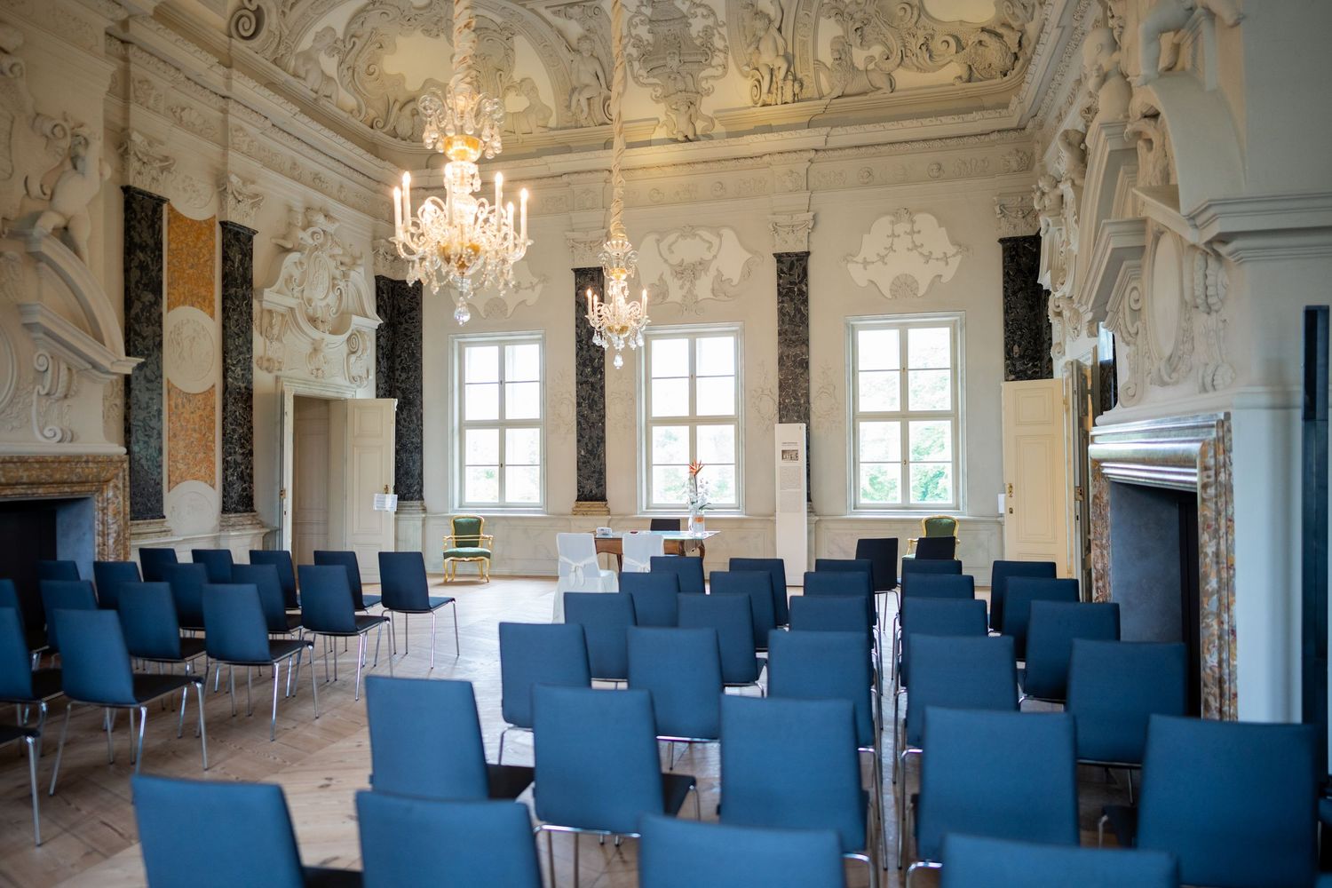 Hochzeitsfotograf Schloss Mirow – leerer Trausaal mit blauen Stühlen vor der Trauung