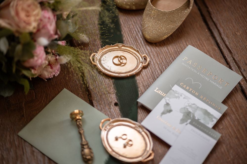 Flatlay des accessoires de la mariée : alliances, bijoux, chaussures et papeterie.