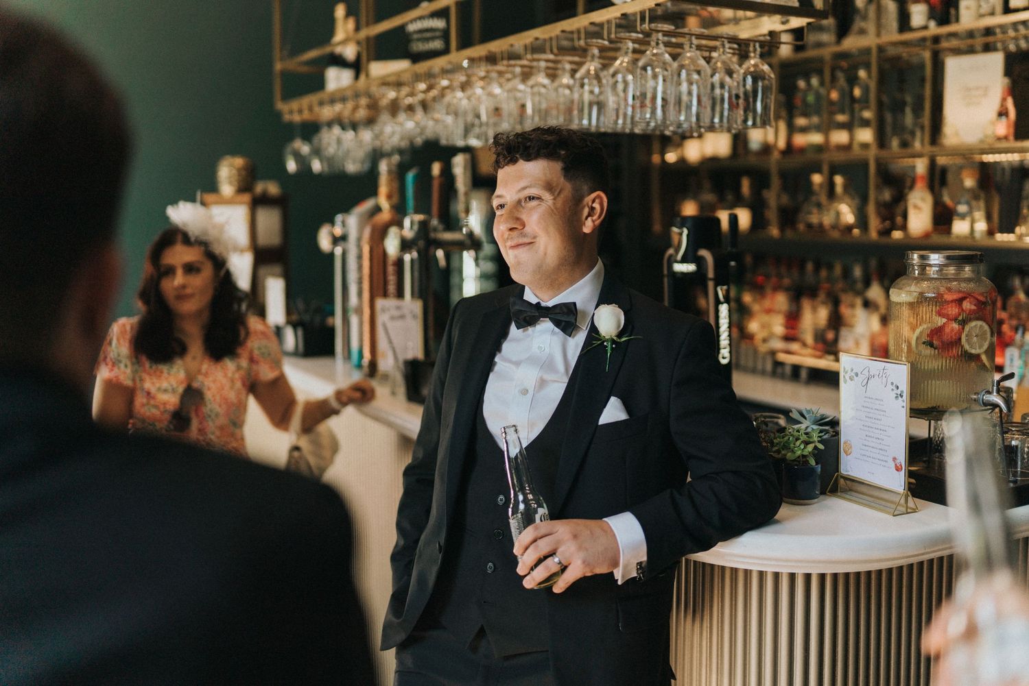 A well-dressed person in a black tuxedo and bowtie stands at an elegant bar at Saltmarshe Hall - taken by Grimsby photographer.