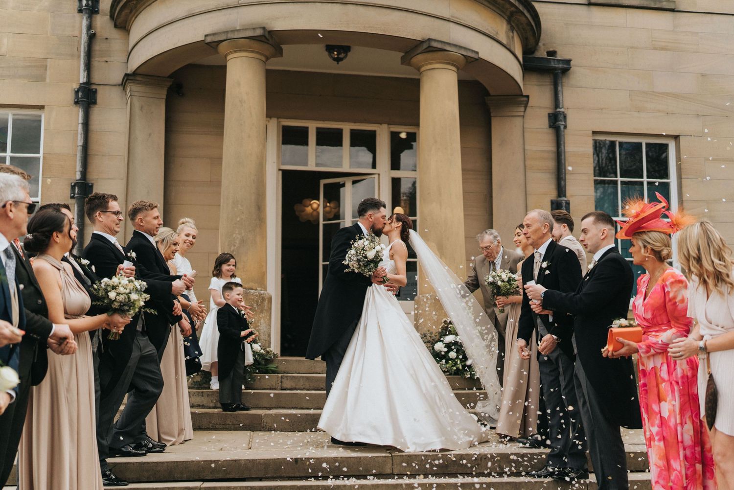 Wedding guests gather on stone steps outside Saltmarshe Hall to celebrate special moment - taken by Grimsby photographer.