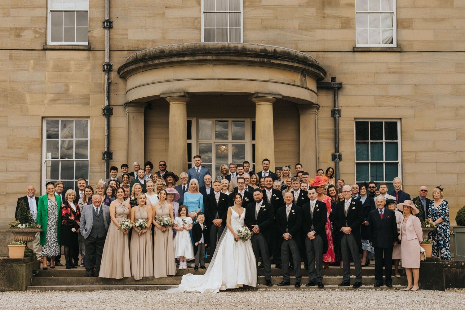Large group wedding photo of guests and bridal party standing in front of Saltmarshe Hall - taken by Grimsby photographer.