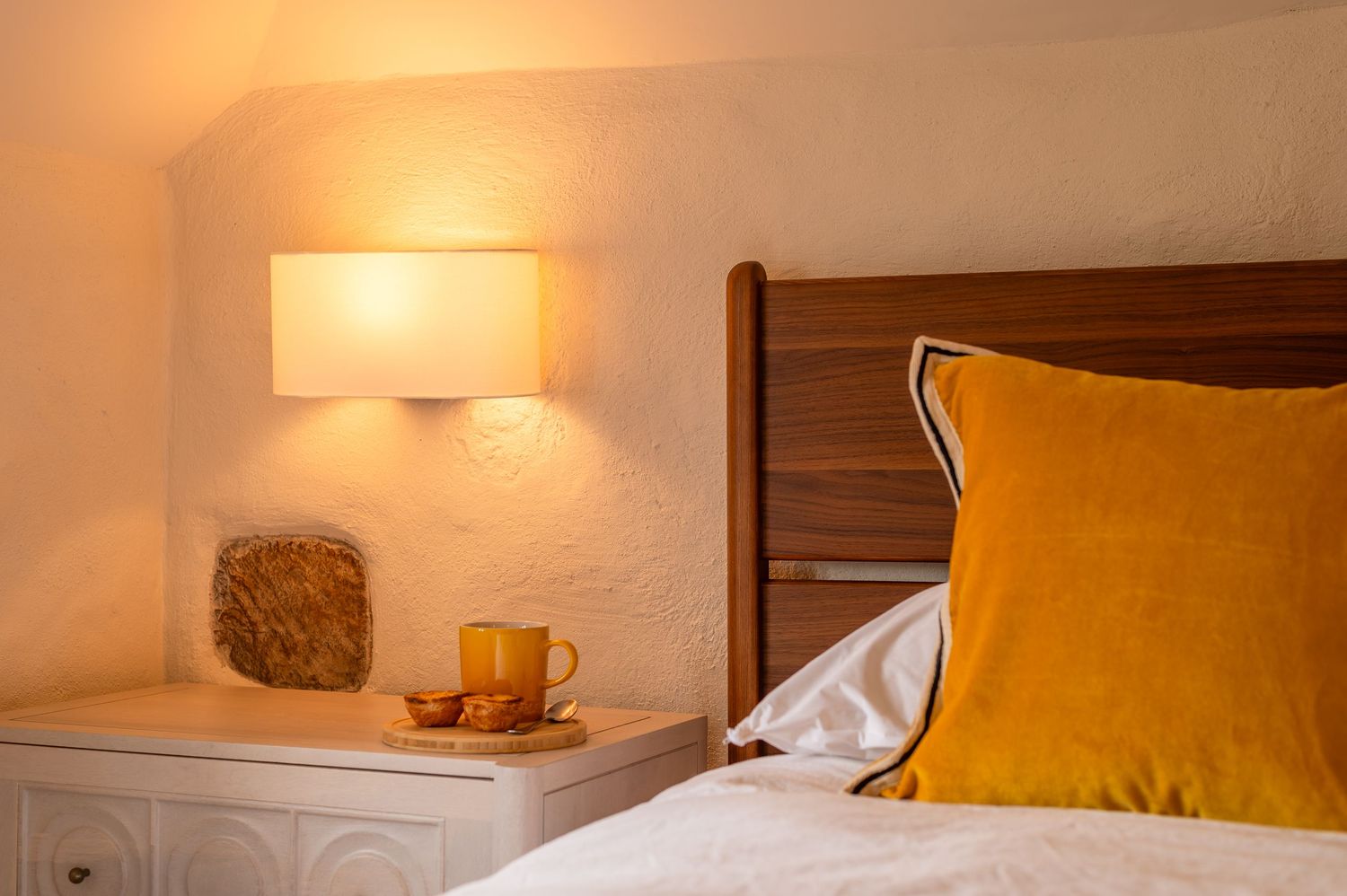 bedside table scene with warm tones and exposed stonework