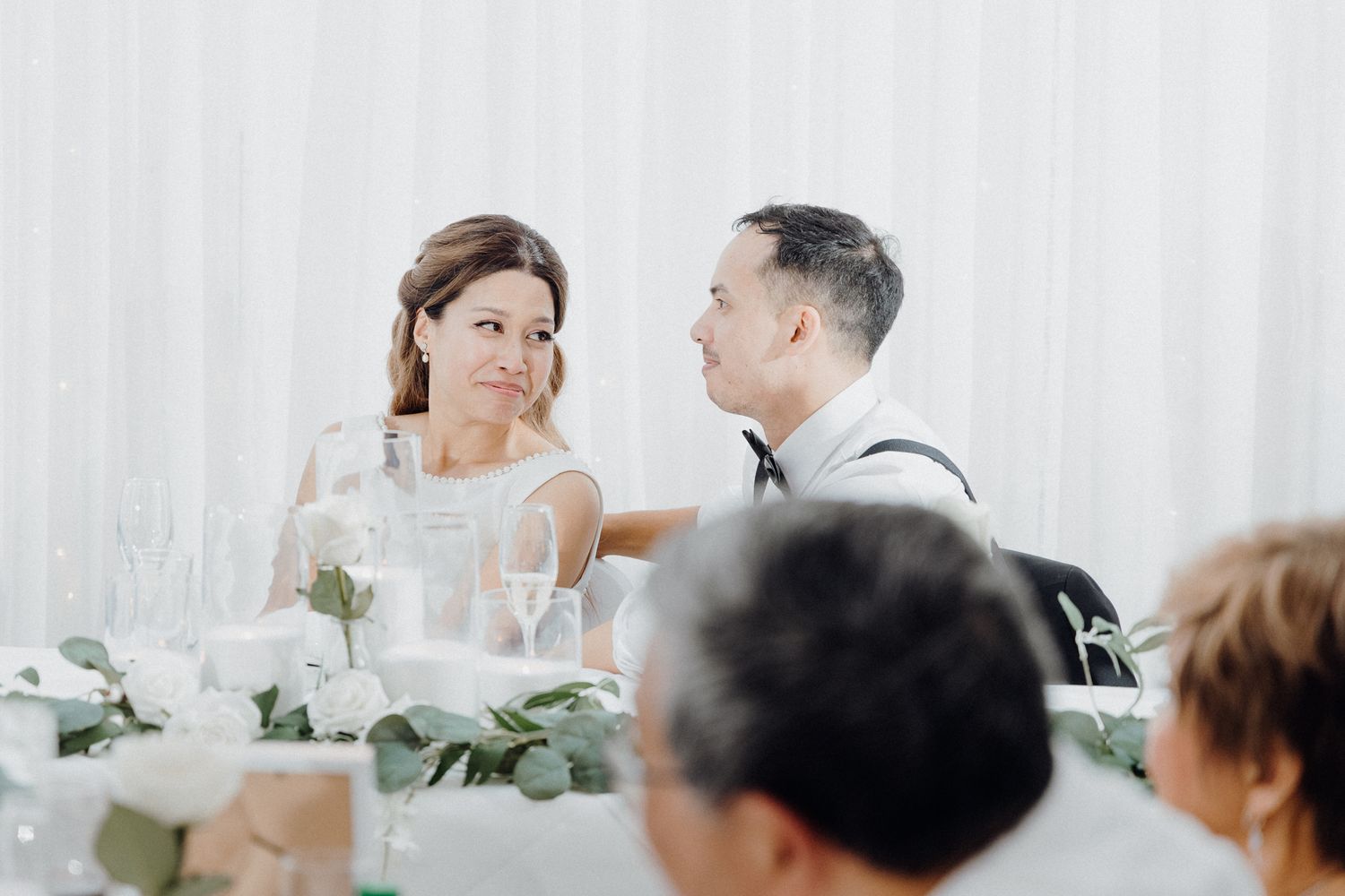 Elegant couple at their wedding reception dining table captured by Apertured Media Auckland Wedding Photographer.