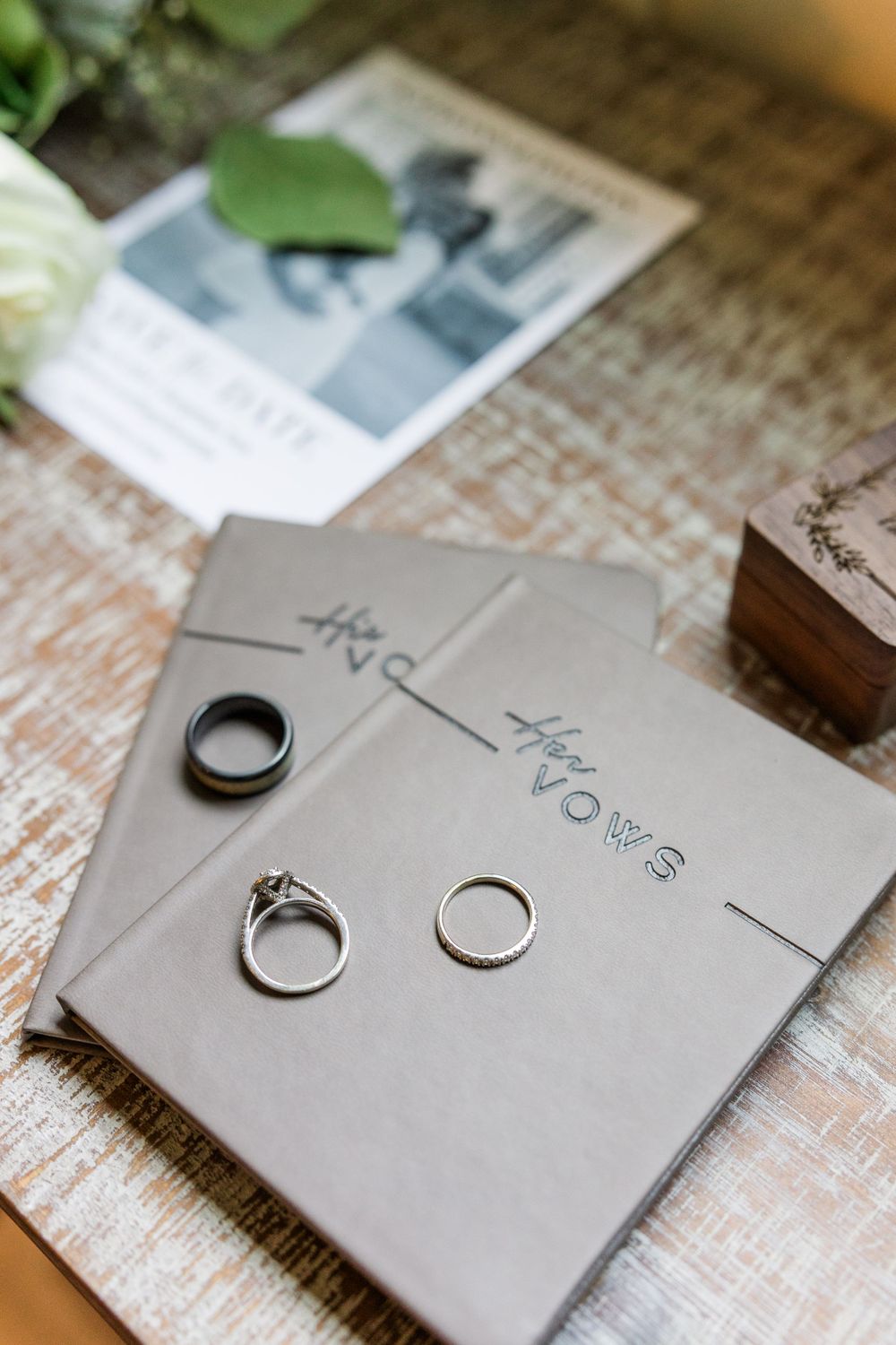 Three wedding rings arranged on gray cards with text on a distressed white wooden surface.