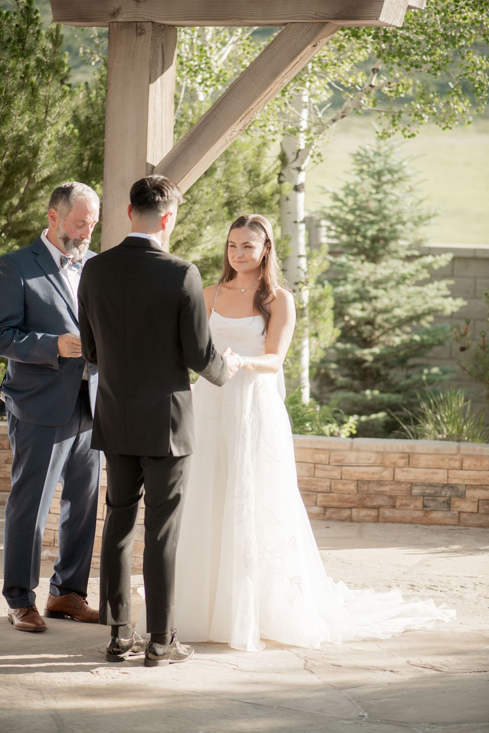 Wedding ceremony moment captured in sequence as couple exchanges vows under covered outdoor venue.