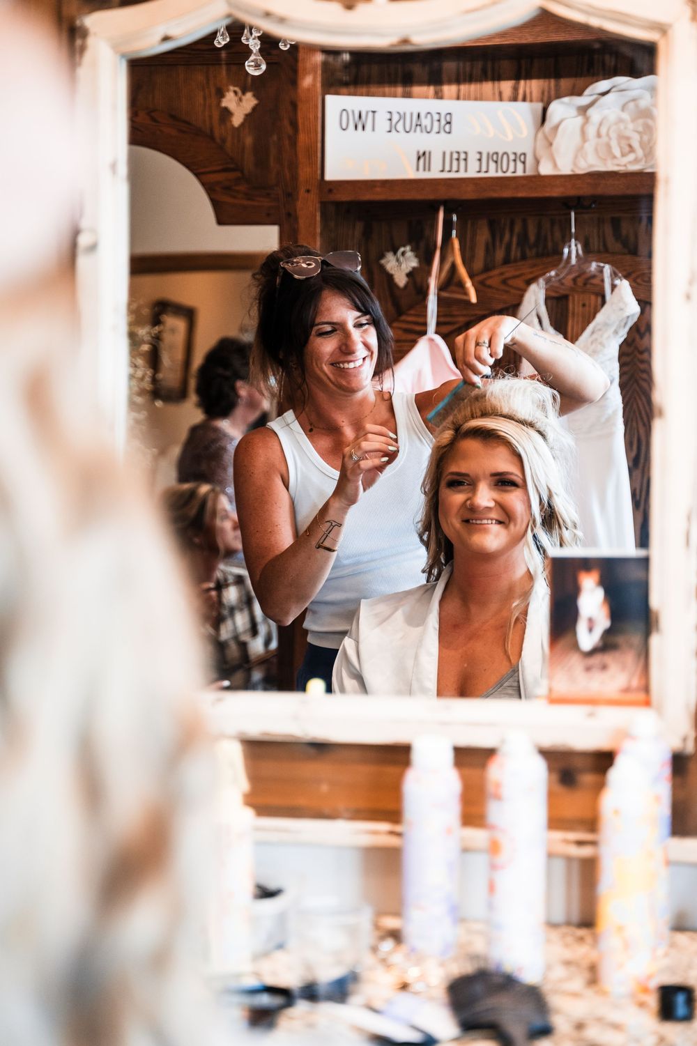 Wedding preparation scene through window frame with joyful expressions.