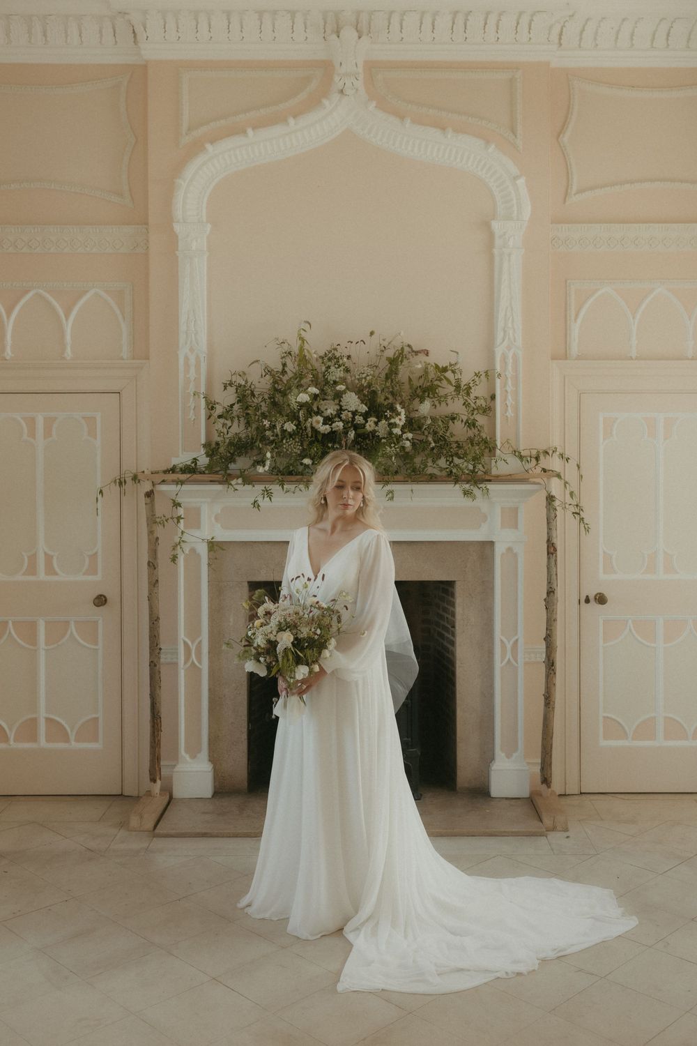 A series of white bridal portraits showing an ethereal wedding gown with flowing sleeves in an elegant cream-colored room.