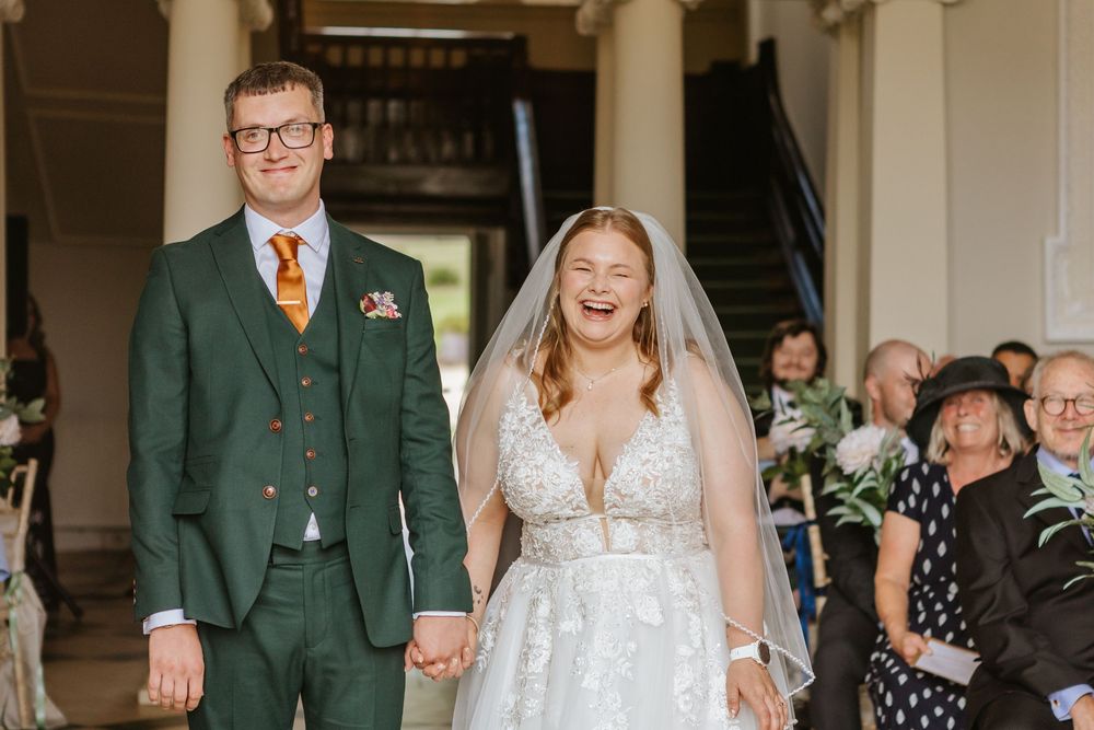 A bride and groom share their first dance together at their wedding reception in a beautiful indoor venue.