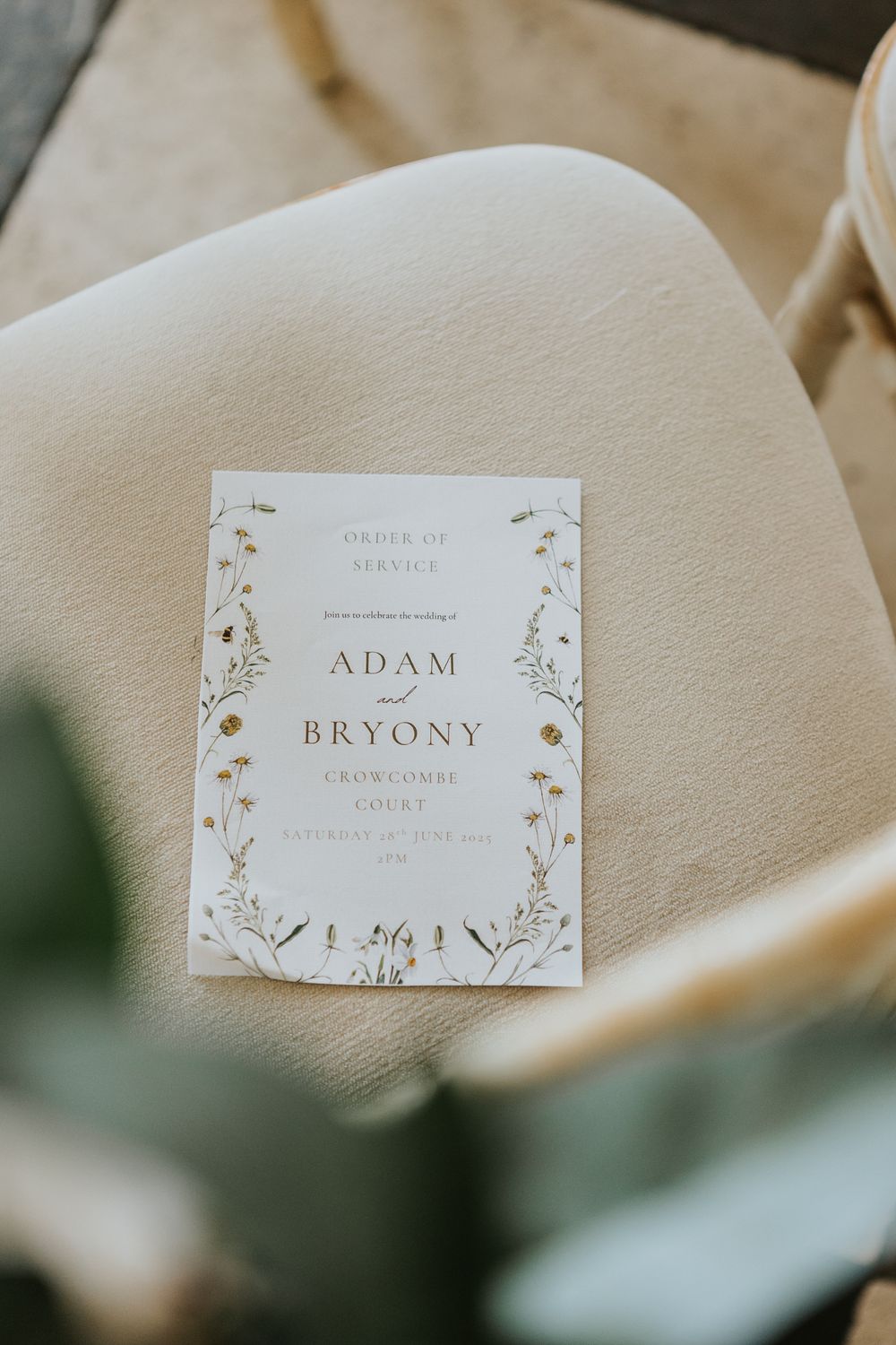 Elegant wedding place cards with delicate floral designs and names printed in gold on cream colored paper.