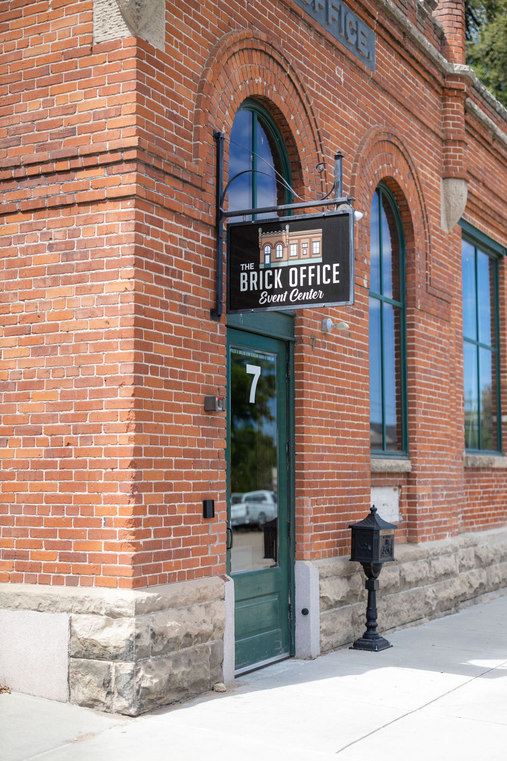 Historic brick building entrance with Brick Office sign and arched doorway.