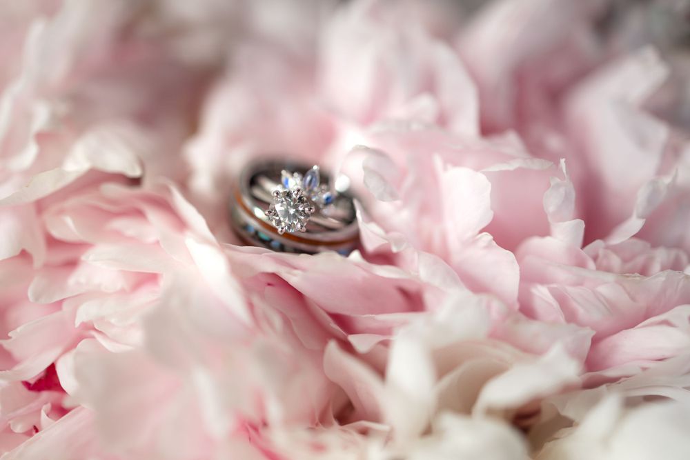 Diamond engagement ring nestled in soft pink peony petals.