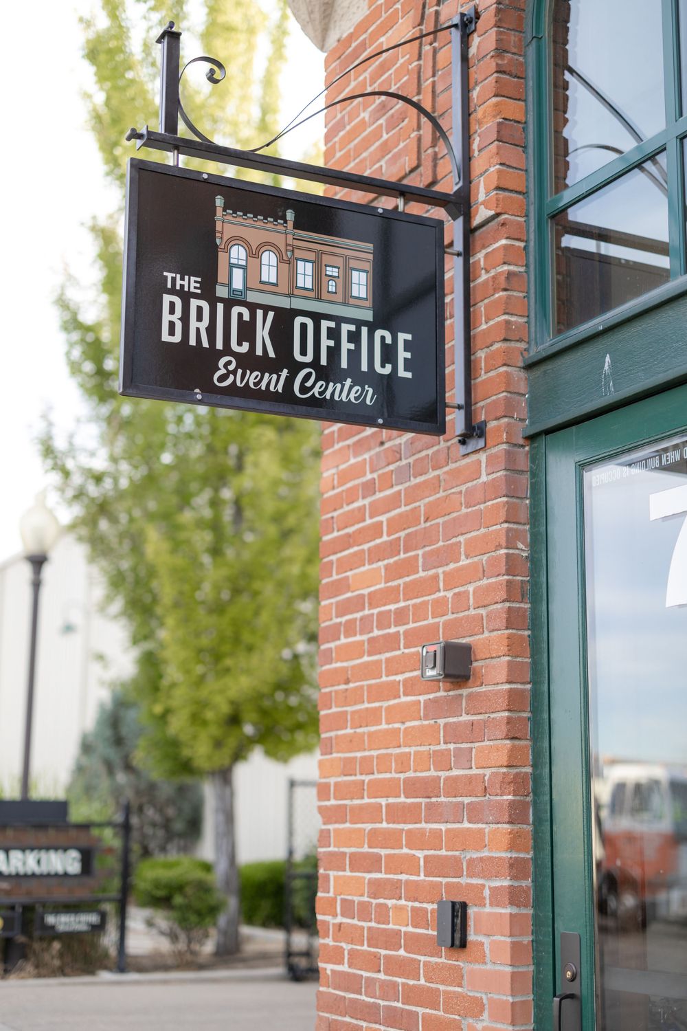 The Brick Office event center sign mounted on exterior brick wall.