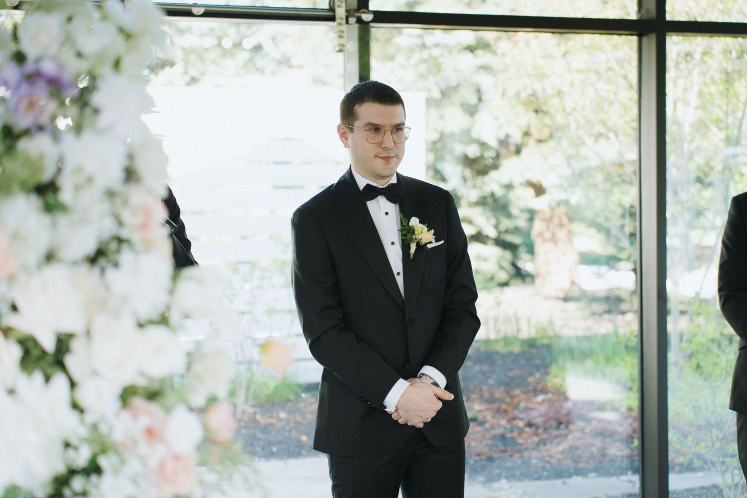 Wedding ceremony space with elegant white decor and floor-to-ceiling windows.