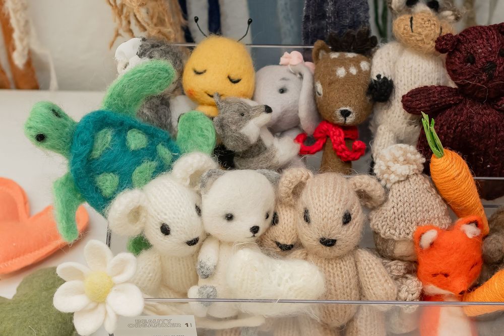 A collection of cute plush toys including soft bunnies, teddy bears, a peacock, sun pillow, and carrot arranged together.