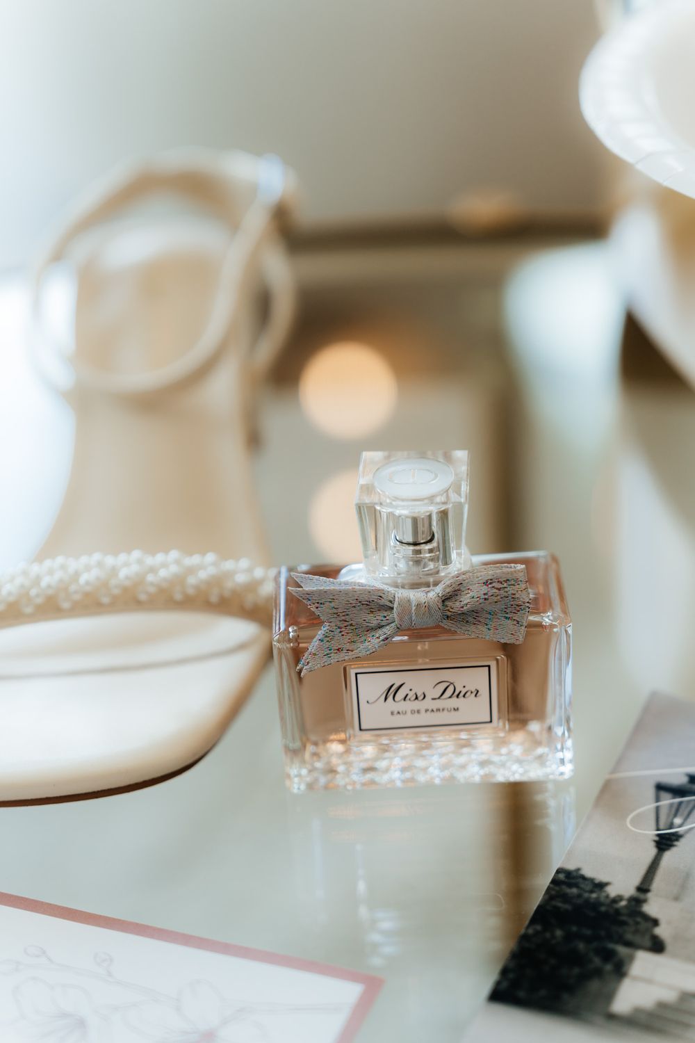 Miss Dior perfume bottle displayed elegantly with bridal accessories on a light surface.