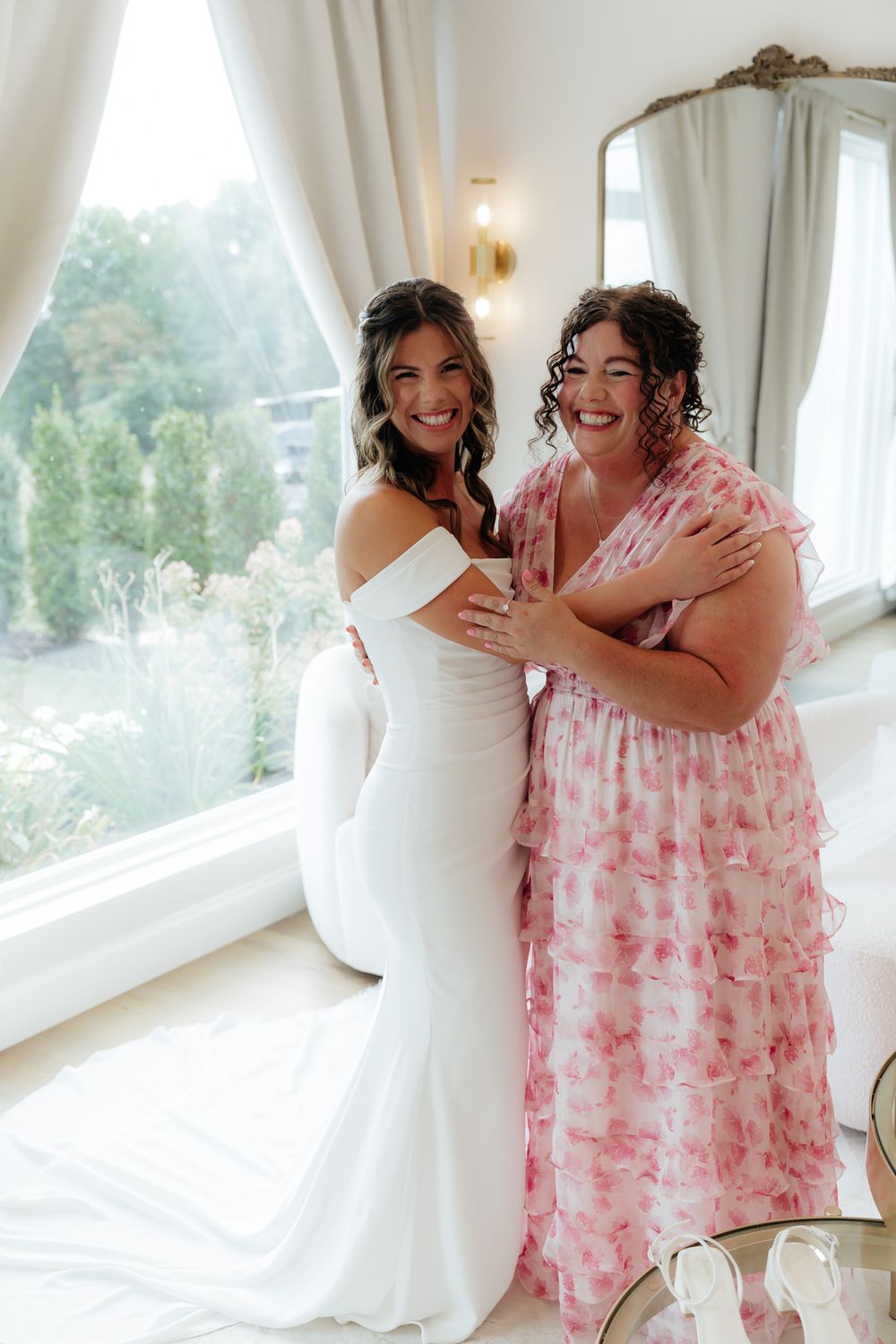 Two joyful people sharing a happy moment in a bright room with large windows.
