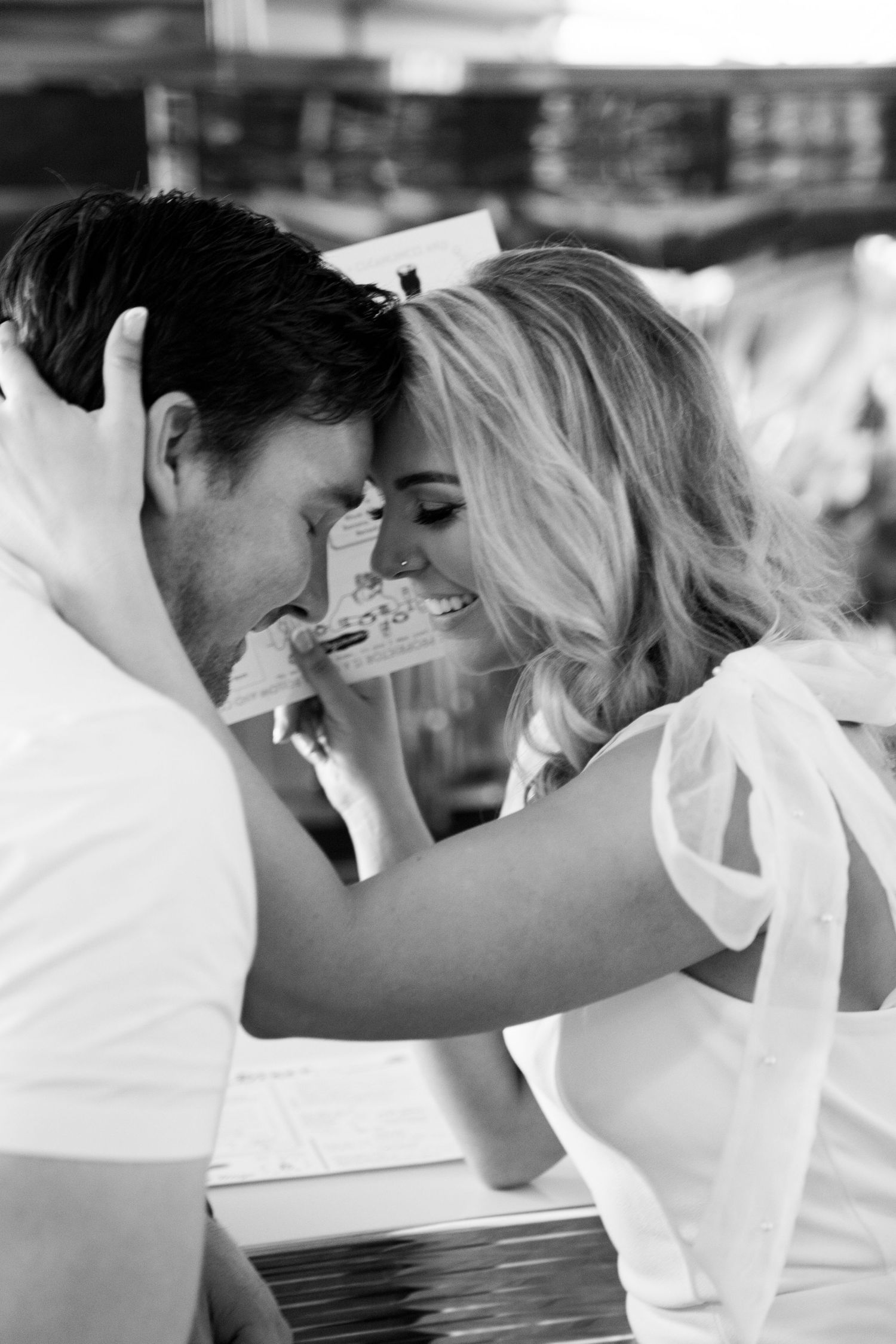 Intimate black and white portrait of couple sharing close moment at diner counter. Jessica Paige Photo Co. Best Wedding Photographer.
