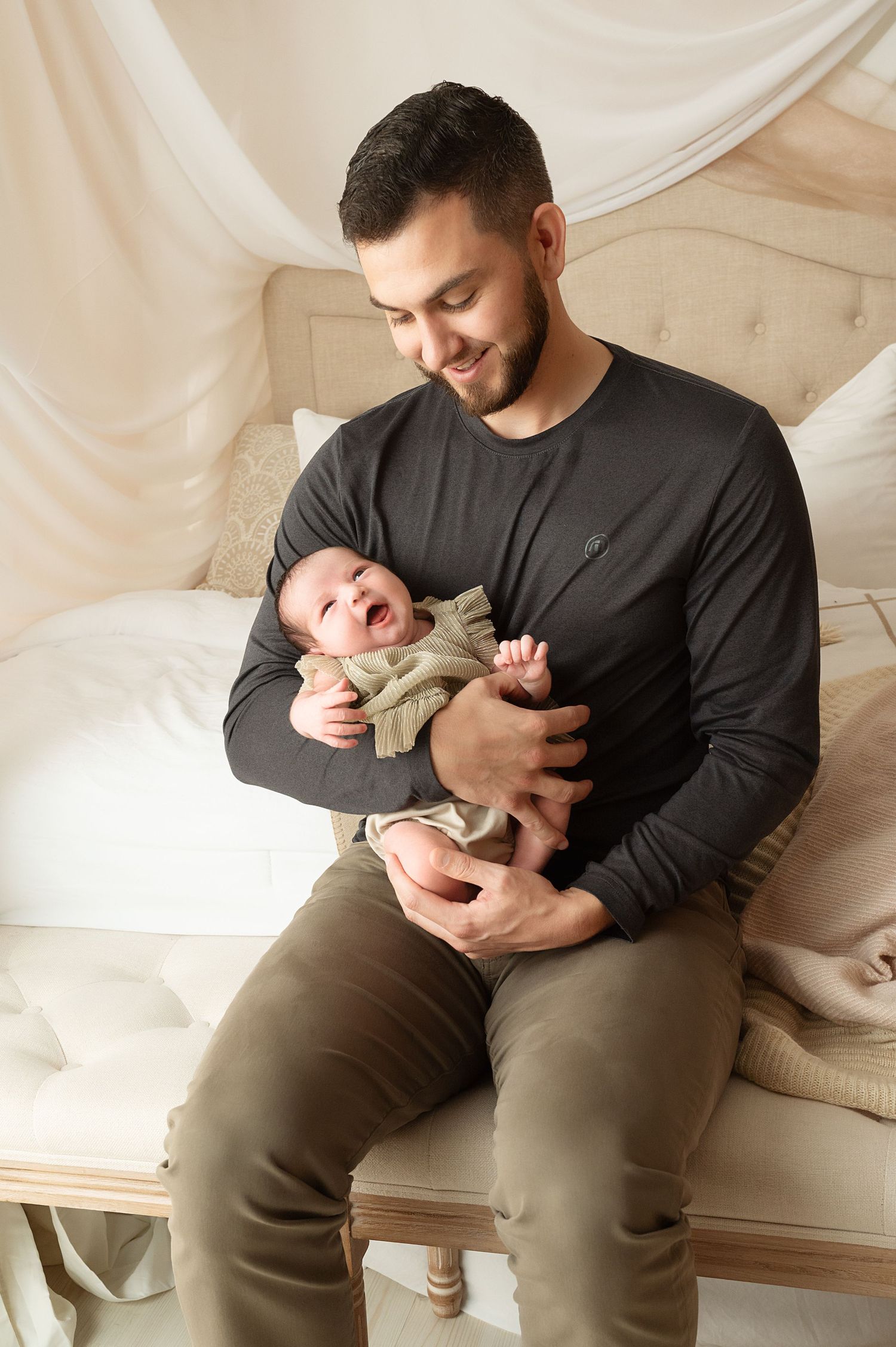 Father and baby bonding moments captured in studio with natural expressions.