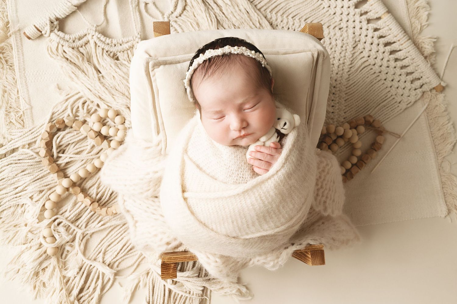 Dreamy newborn portraits with textured cream fabrics and delicate styling.