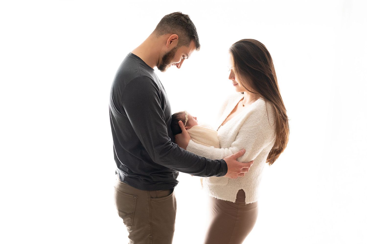 Professional maternity photo sequence showing parents gently embracing in a studio filled with natural light.