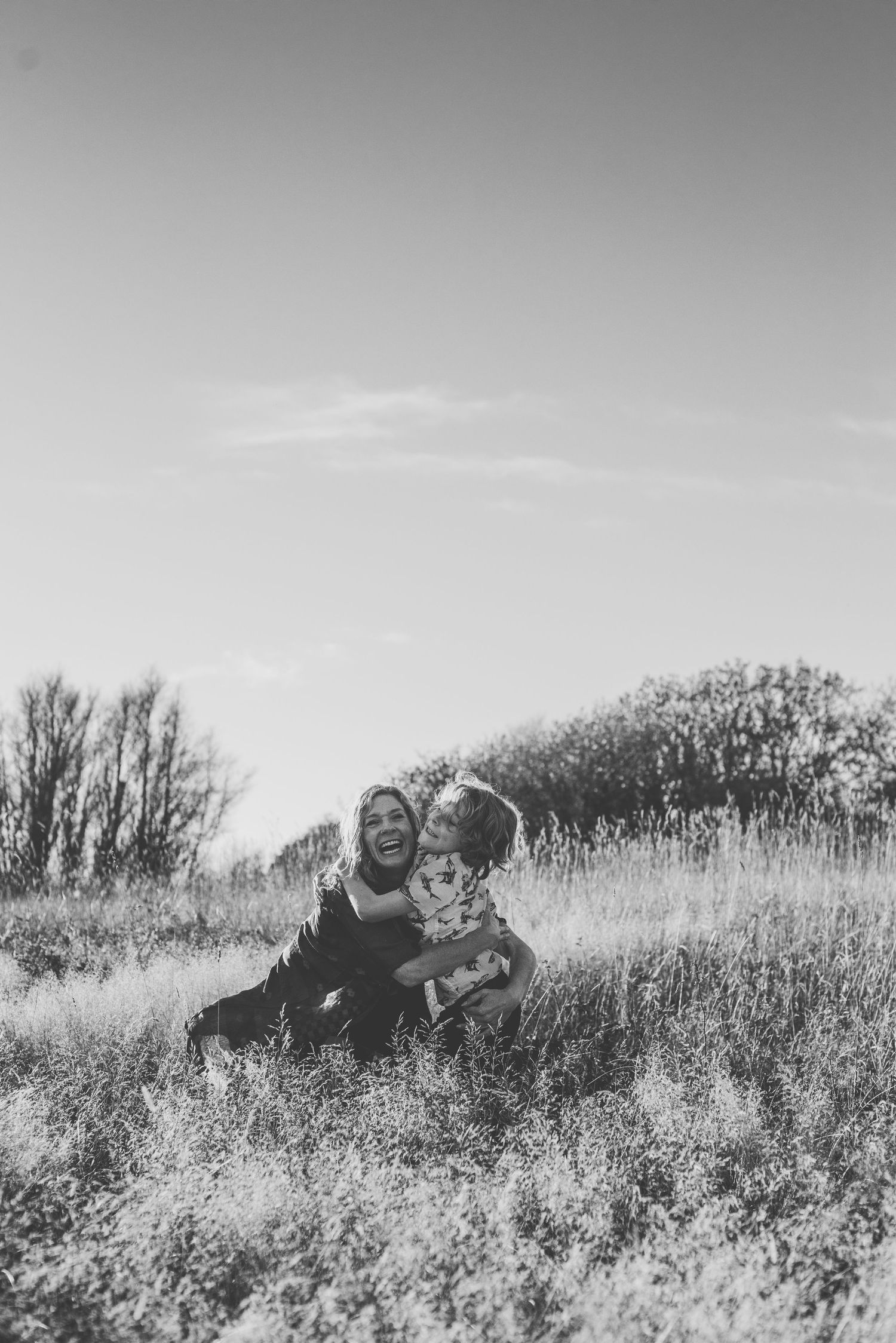 People sitting together in a sunlit meadow with tall grass.