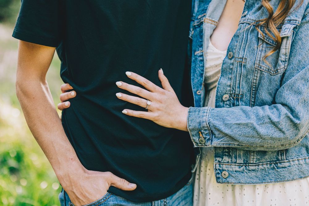 Close-up shot of two people embracing, with one wearing a black shirt and the other in a denim jacket.