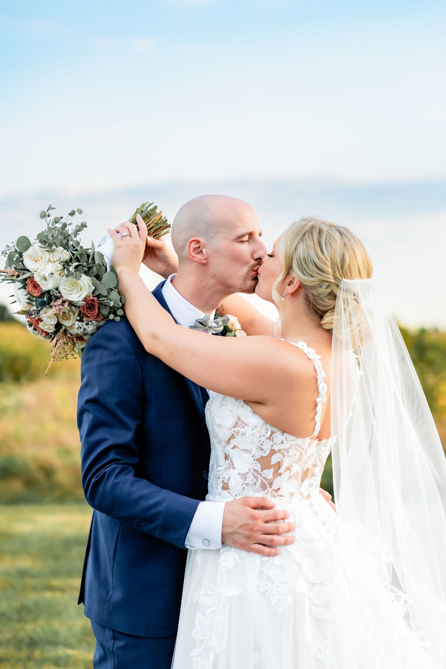 Romantic moment captured between newlyweds on their wedding day in an outdoor setting.